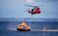 Coast guard training with a helicopter and a cutter.