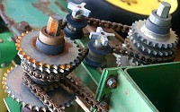 Agriculture machinery with gears and chains in a pulley like configuration.
